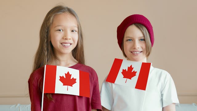 Niños sosteniendo banderas de Canadá, sonriendo